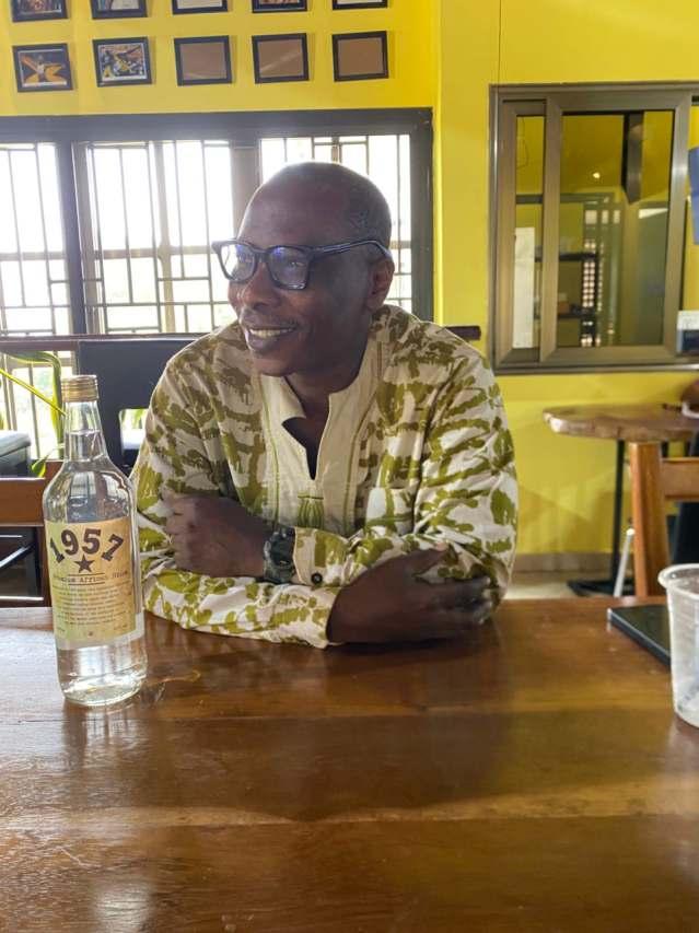 Writer Kofi Akpabli with a bottle of Ghanaian akpeteshie